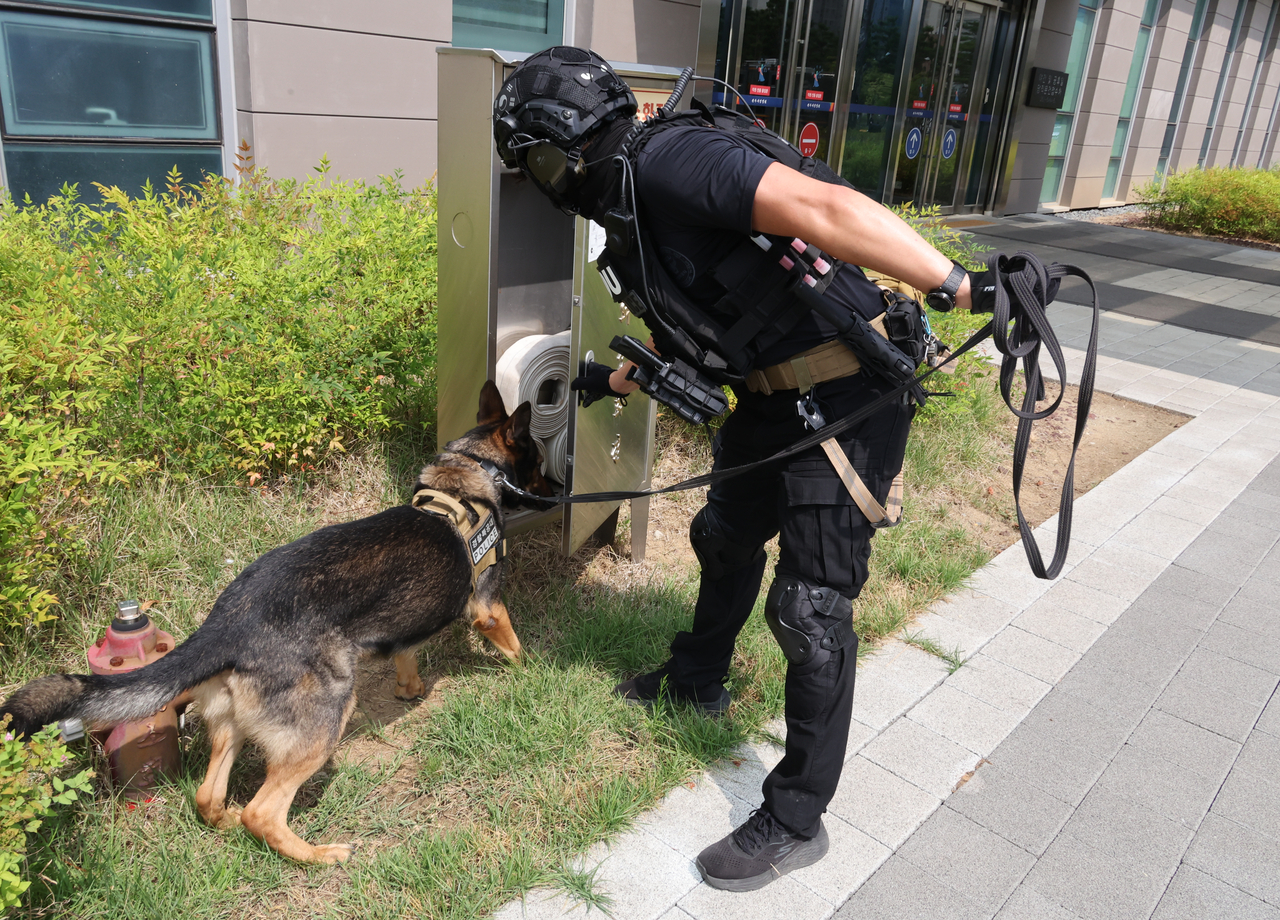 A police dog searches the premises of Jeonju District Court in North Jeolla Province on Wednesday after the courthouse received an email threatening an explosion. (Yonhap)