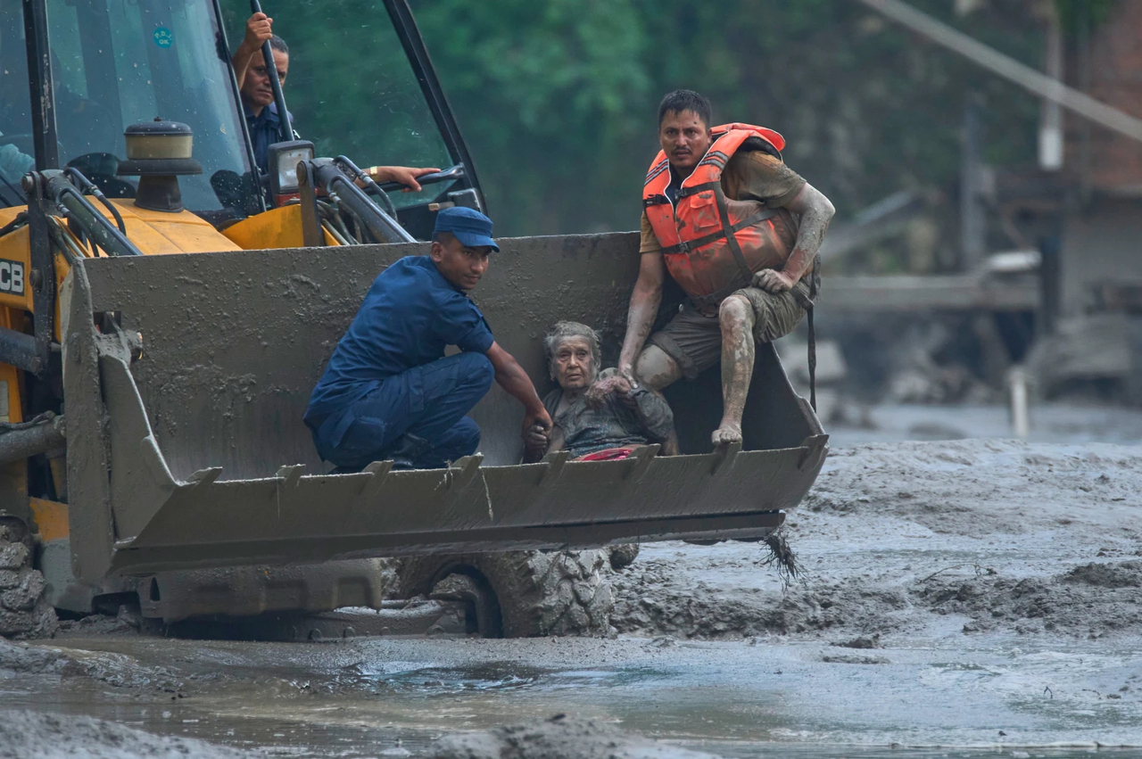 Rescuers use an earthmover to carry a victim of flash flooding to safety along the Trishuli River in Nepal’s Nuwakot district, Wednesday, Aug. 26, 2026. (AP)