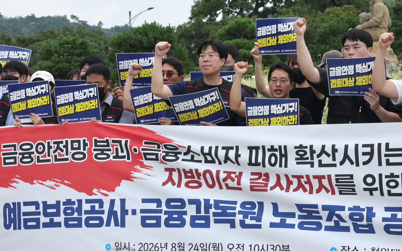 Members of the Financial Supervisory Service and Korea Deposit Insurance Corp. labor unions chant slogans during a rally near Cheong Wa Dae in Seoul on Monday, opposing the relocation of financial institutions outside the capital region. (Yonhap)