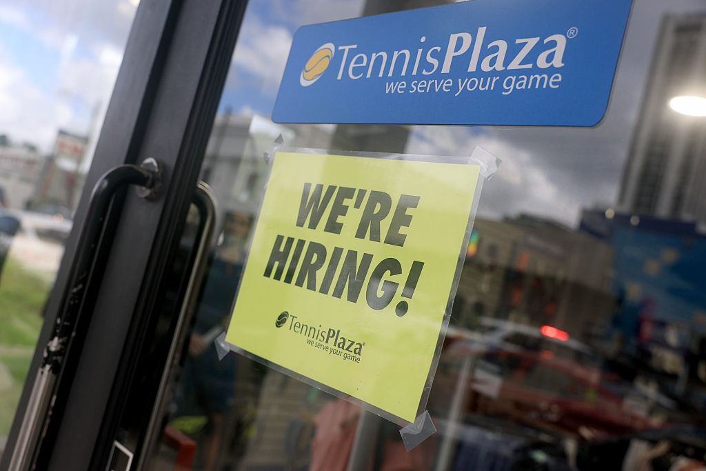 A "Now Hiring" sign is displayed at a store in Miami, Florida. [Getty Images]