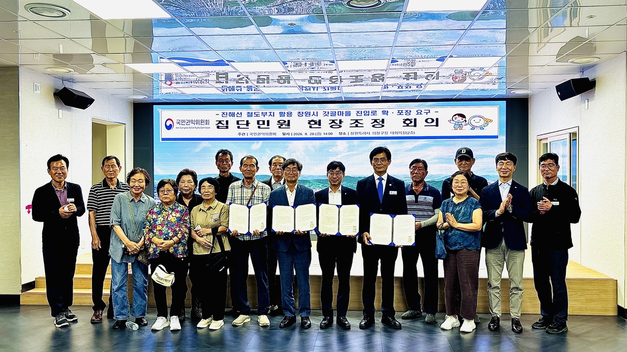 28일 창원시 의창구청에서 열린 국민권익위 현장조정회의에서 정일연 국민권익위원장과 정호원 제2부시장, 마을 주민들이 ‘반계동 갓골마을 진입로 확장’ 합의를 마친 뒤 기념촬영을 하고 있다. [창원시 제공]