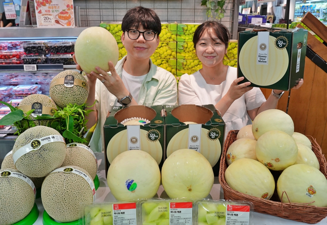 지난 27일 서울시 송파구에 위치한 롯데마트 제타플렉스 잠실점 과일 매대에서 (왼쪽부터) 이규원·안정희 롯데마트 과일팀 MD(상품기획자)가 대형마트 단독으로 선보이는 ‘허니듀 킹메론’을 선보이고 있다. [롯데마트 제공]