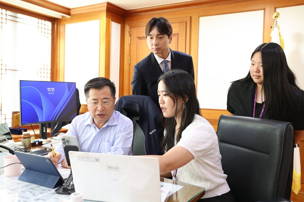 KOTRA President Kang Kyung-sung (center) meets with junior employees on Aug. 10 as part of the agency's new reverse-mentoring program, discussing topics including AI use and cross-generational communication. [KOTRA]
