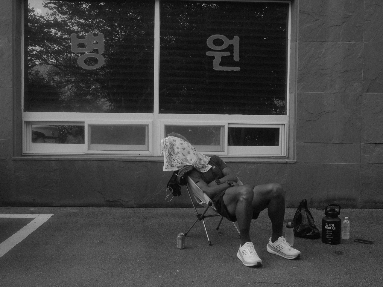 Zay rests in a collapsible chair during his 10-day run from Seoul to Busan. The chairs were among the lessons his team carried over from his first cross-country run. (Emile Justin Appollis, Kim Woo-jin)