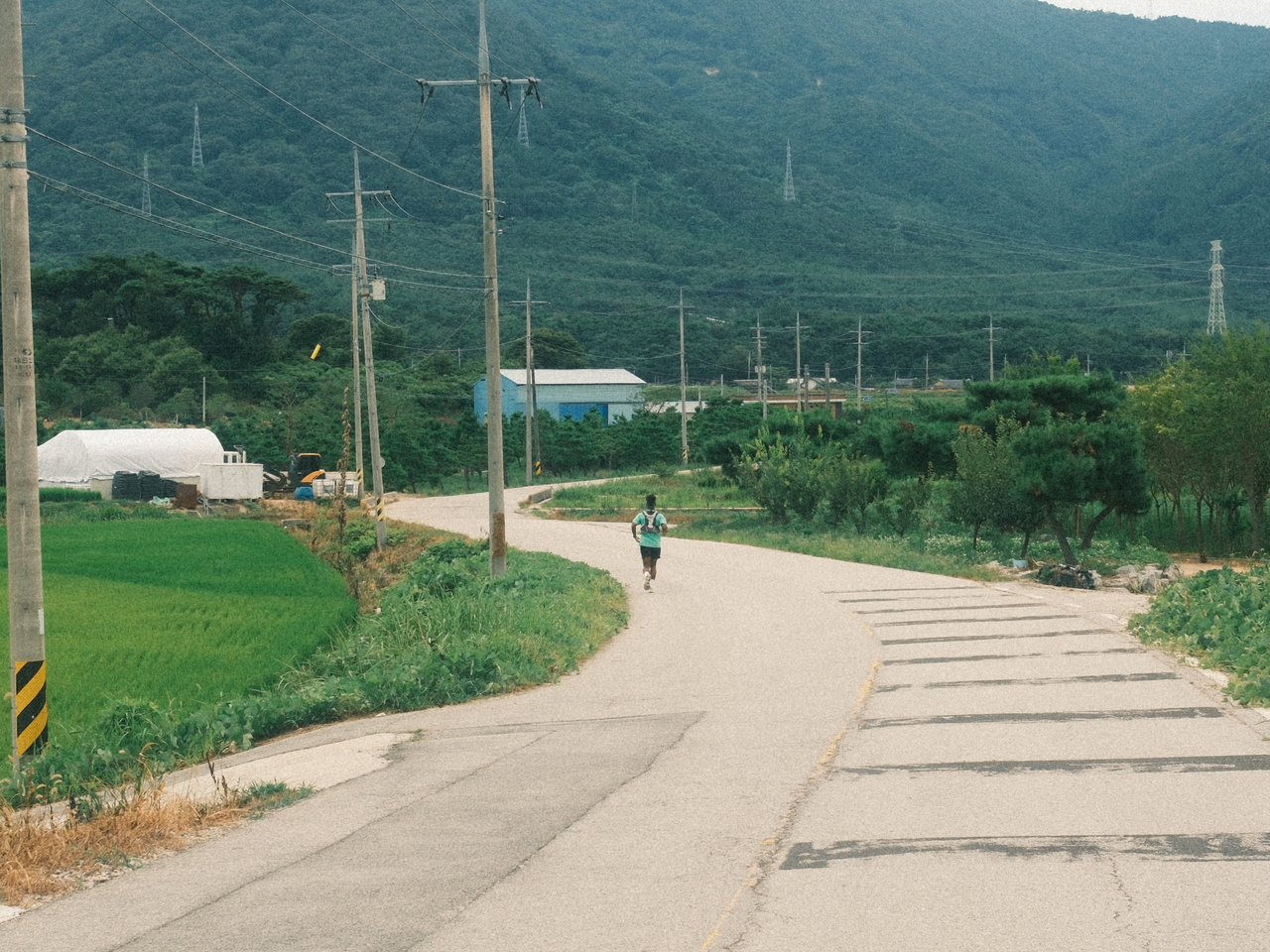 Zay runs along a rural road during his 10-day journey from Seoul to Busan. (Emile Justin Appollis, Kim Woo-jin)
