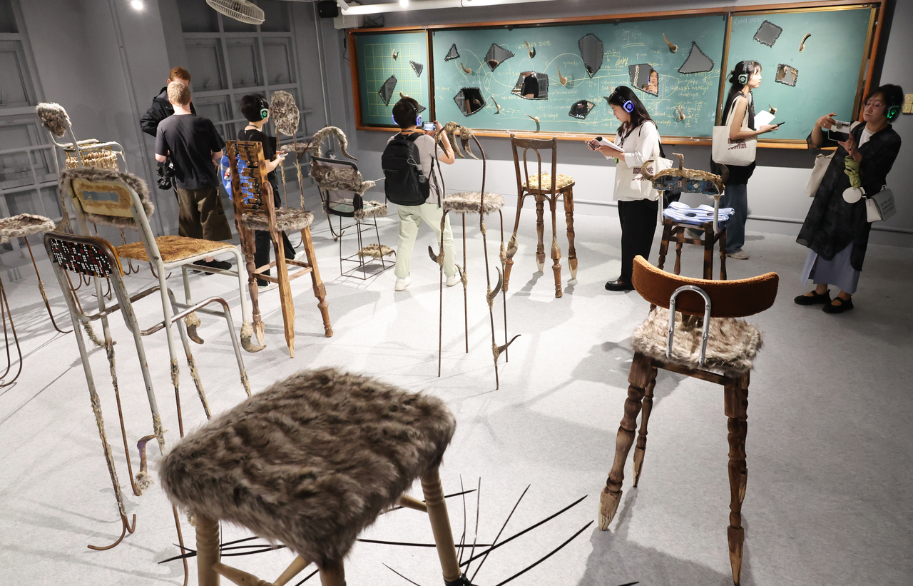 Participants look at artworks during a press preview of the Busan Biennale 2026 at the former Busan Nam High School in Yeongdo-gu, Busan, Friday. (Yonhap)