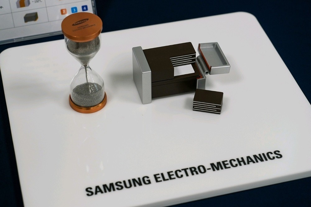 Samsung Electro-Mechanics’ multilayer ceramic capacitors are shown with a scale model highlighting their small size. (Samsung Electro-Mechanics)