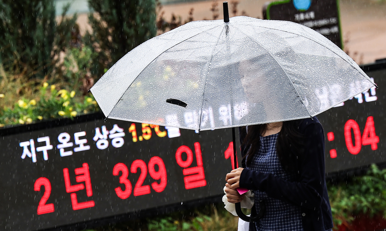 A person walks past a climate clock at Dongdaegu Station in Daegu on Friday. (Yonhap)