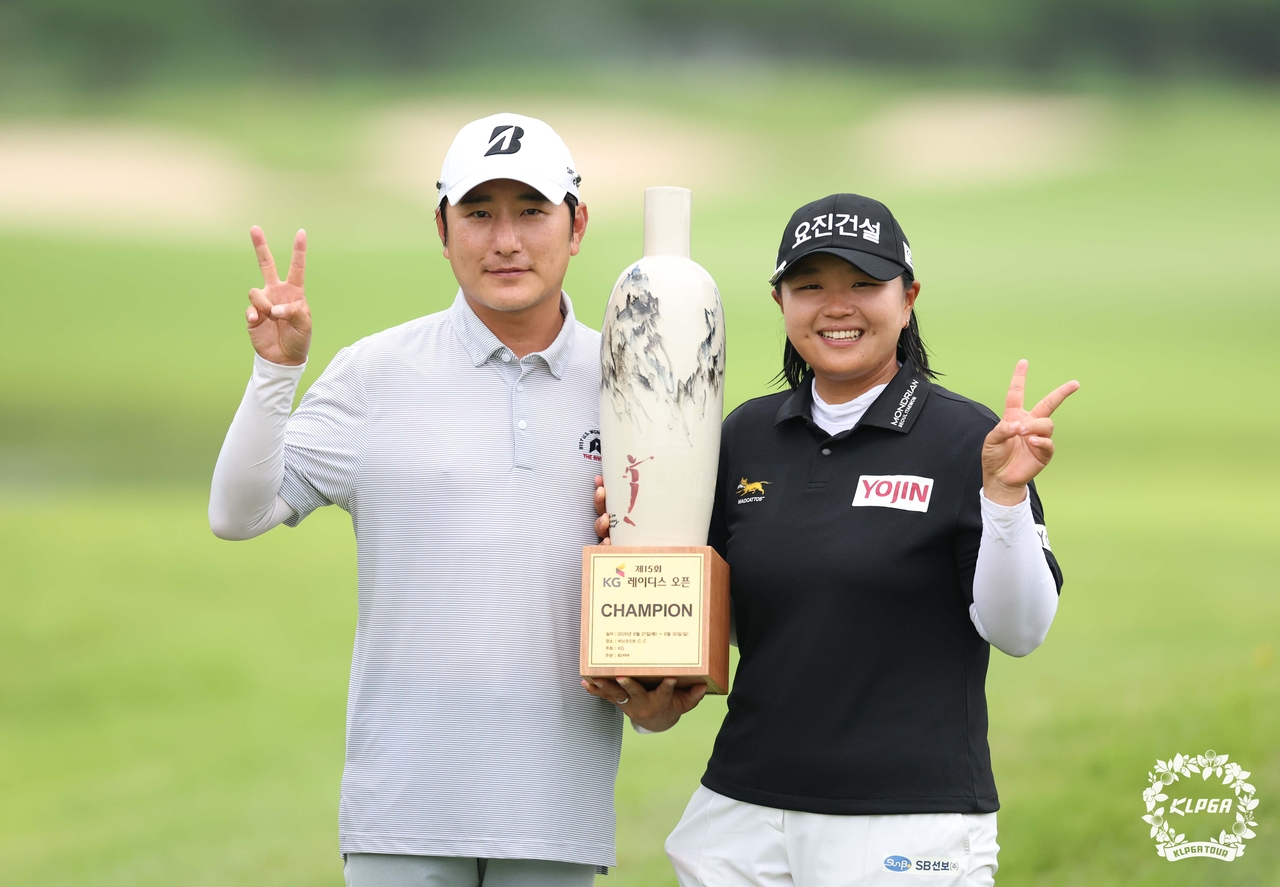 Shin Da-in poses with the winner's trophy alongside her caddie. [Photo=KLPGA]