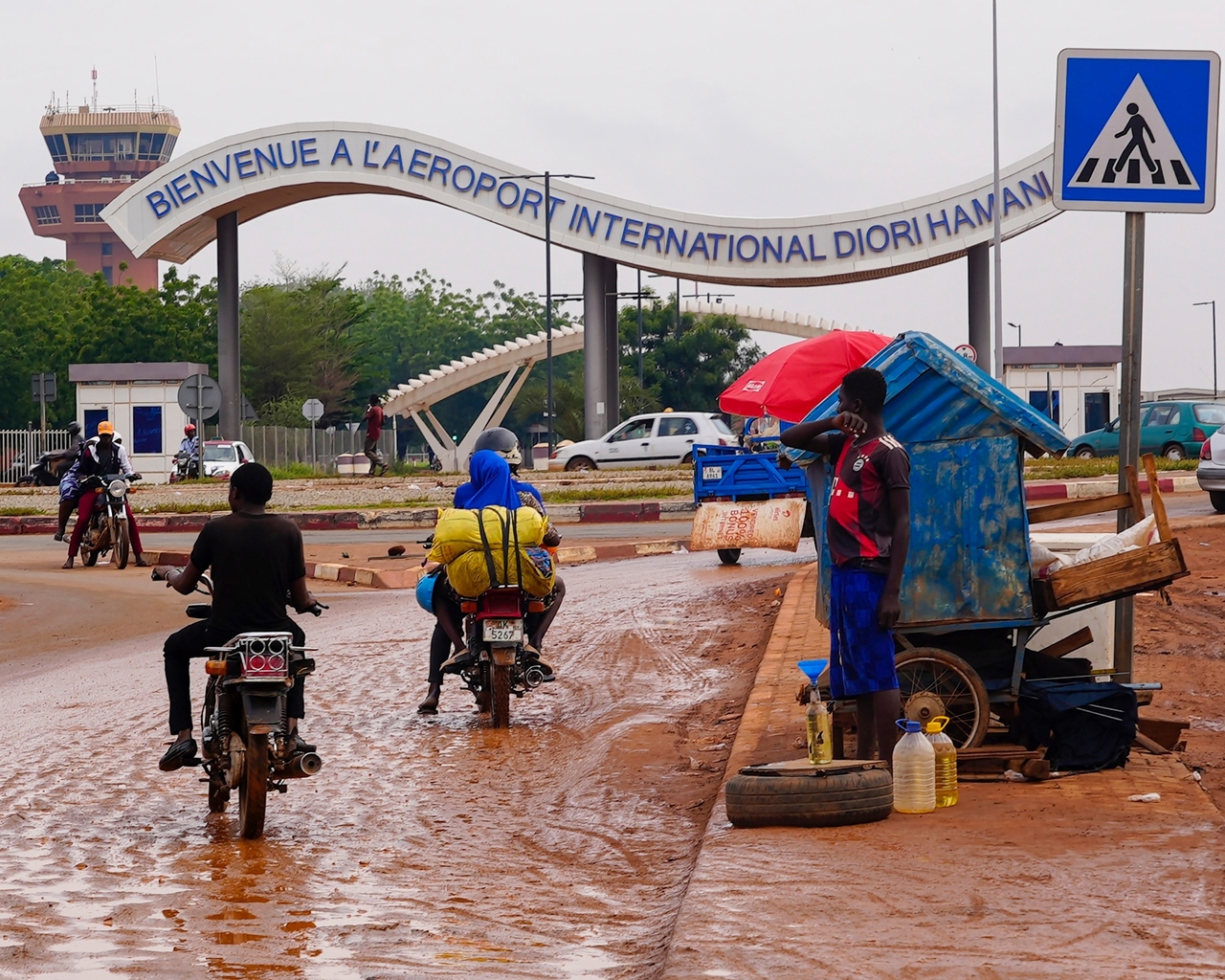 Motorcyclists ride by the entrance of the airport in Niamey, Niger, Aug. 8. (AP-Yonhap)