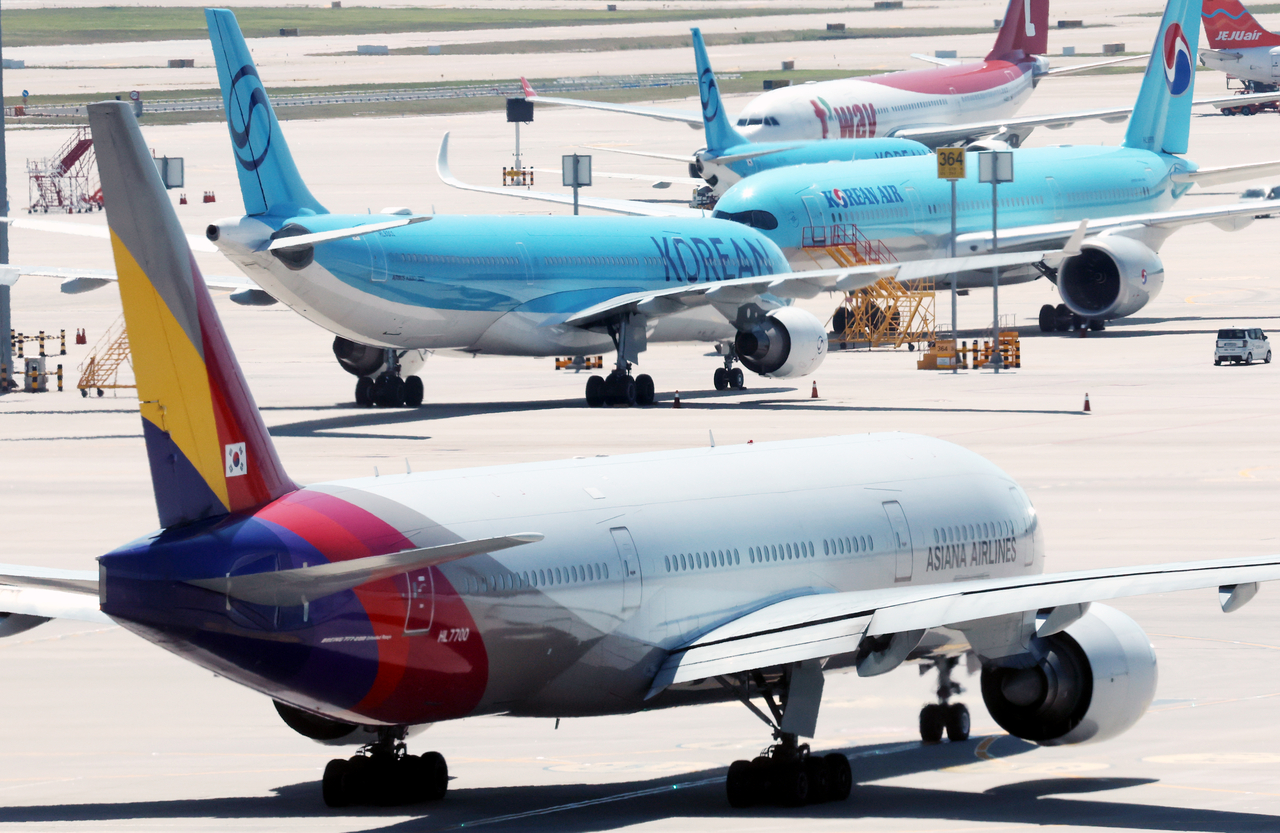 Aircraft operated by Korean Air, Asiana Airlines and Trinity Airways are parked at Incheon Airport on Aug. 12. (Newsis)
