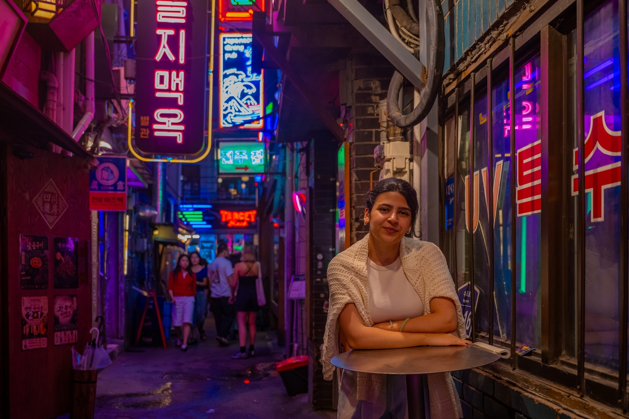 A traveler photographed under the neon signs of Euljiro (Seoul Tourism Organization)