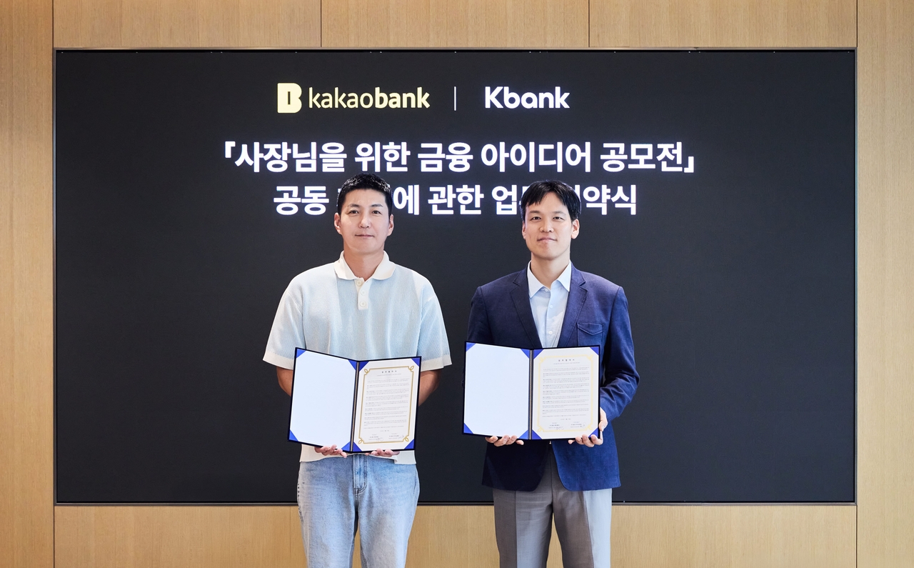 Kim Sung-su (right), head of Kakao Bank's credit division, and Kim Min-chan, head of K bank's Corporate Group, pose for a photo at the MOU signing ceremony for the "Financial Ideas Contest for Business Owners" held at Kakao Bank's Pangyo office in Seongnam, Gyeonggi Province, on Friday. [Kakao Bank]