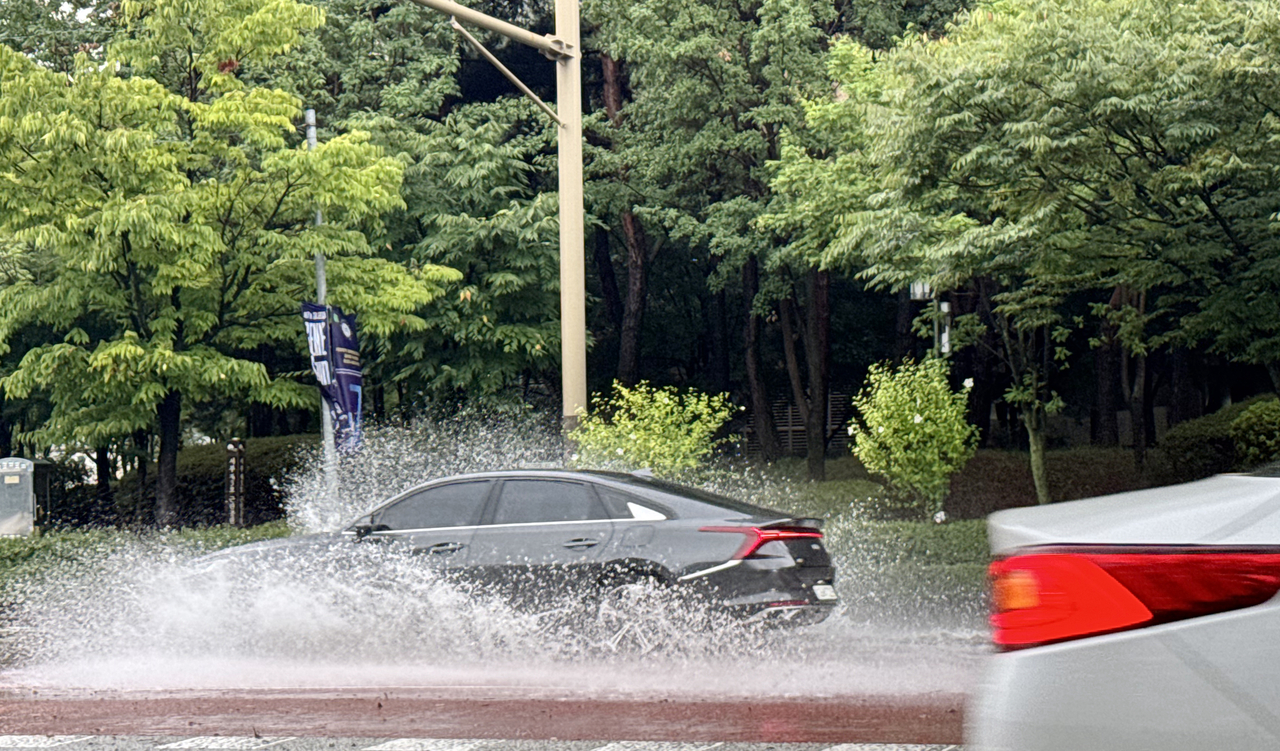A car drives through a rainwater-covered road in Jeonju, North Jeolla Province, Monday. (Yonhap)