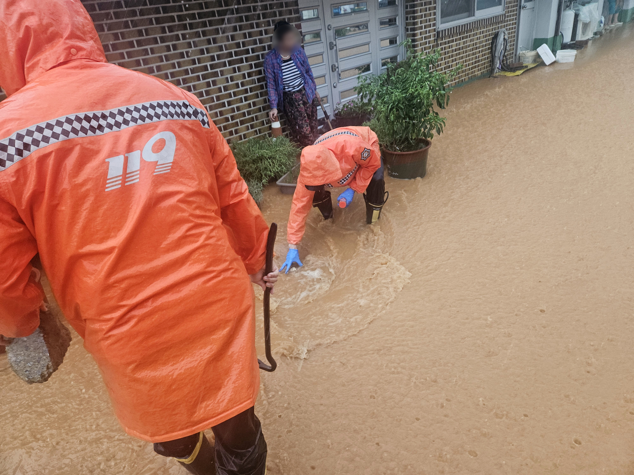 Firefighters carry out drainage work on a flooded road in Gochang-gun, North Jeolla Province, Monday morning. (Jeonbuk Fire Headquarters-Yonhap)