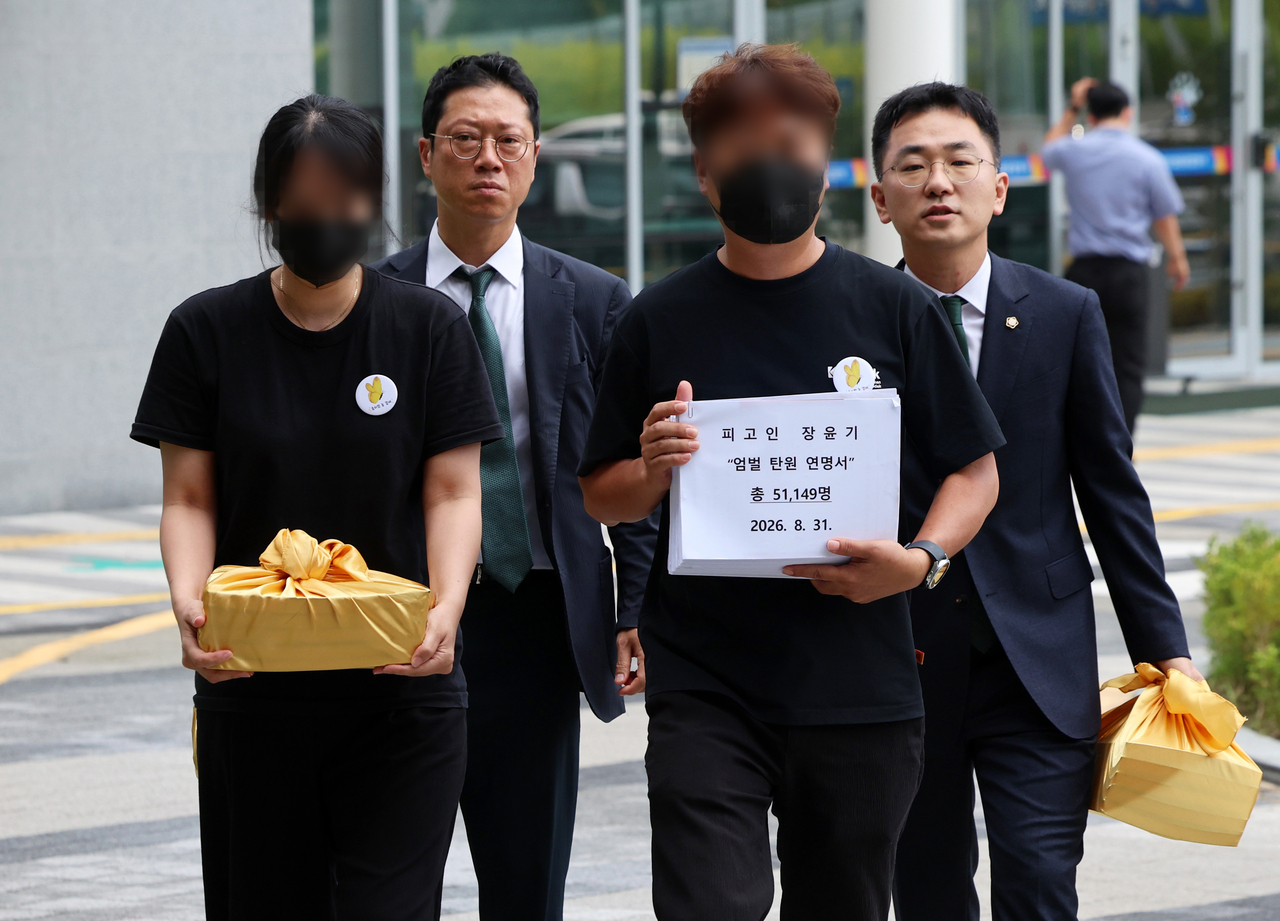 The parents of late Lee Chae-won attend Jang's trial on Monday at the Gwangju District Court to submit a petition calling for Jang to be given the death penalty. (Yonhap)