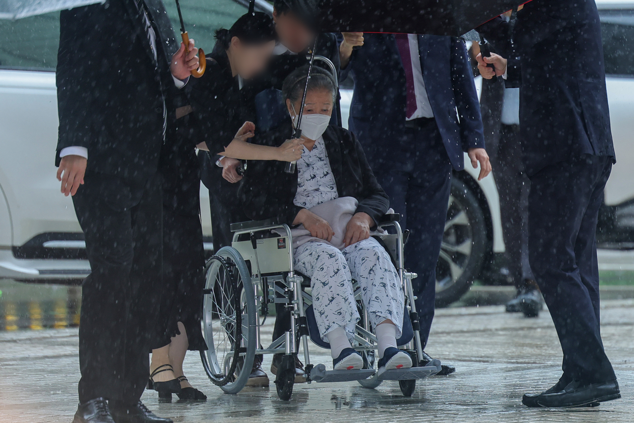 Unification Church leader Han Hak-ja (center) enters the Seoul Central District Court in Seocho-gu, Seoul, on Monday to attend the sentencing on her charge of embezzling church funds. (Yonhap)