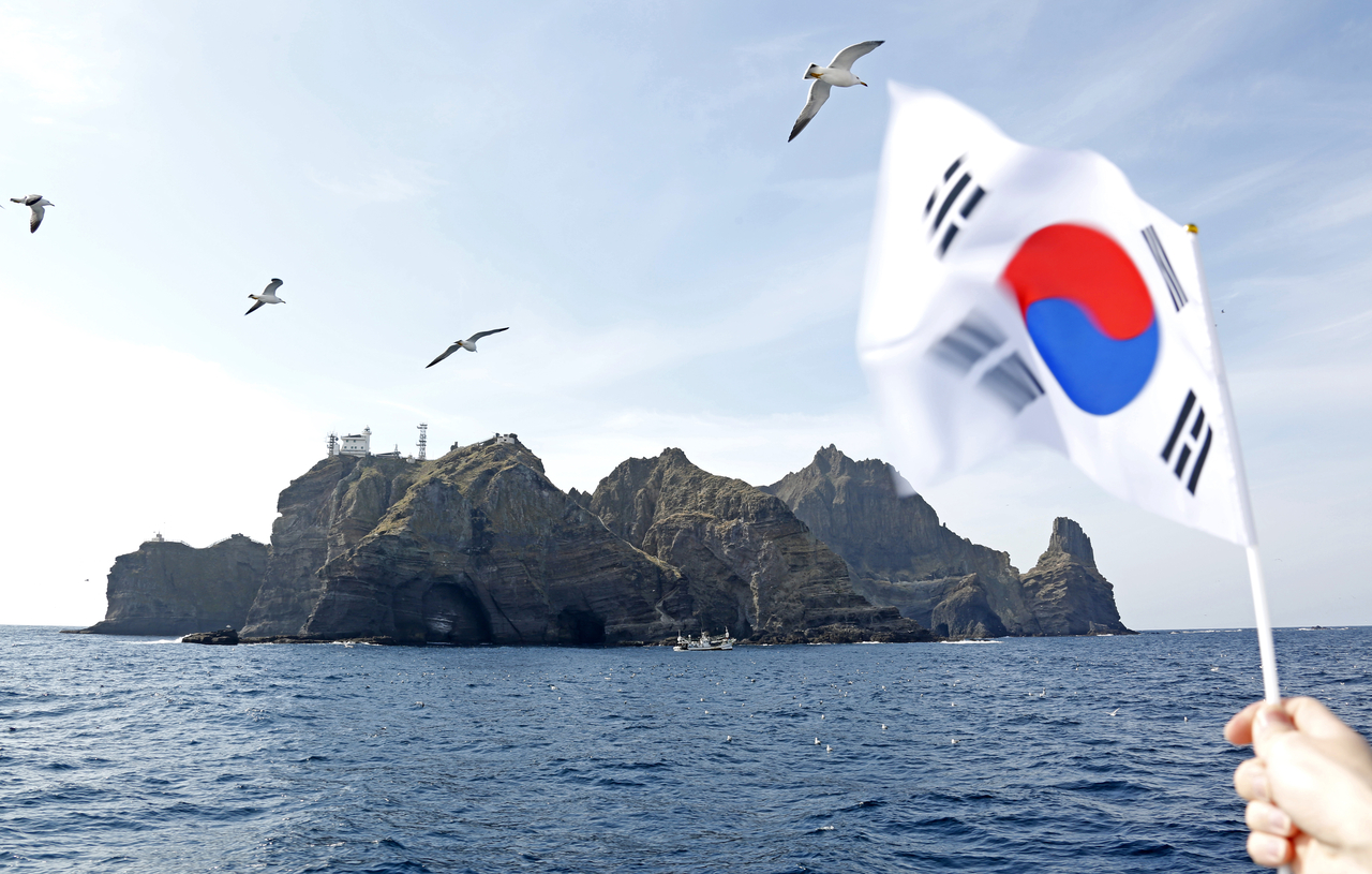 The Taegukgi, South Korea’s national flag, is seen against the backdrop of the Dokdo islets. (Getty Images)