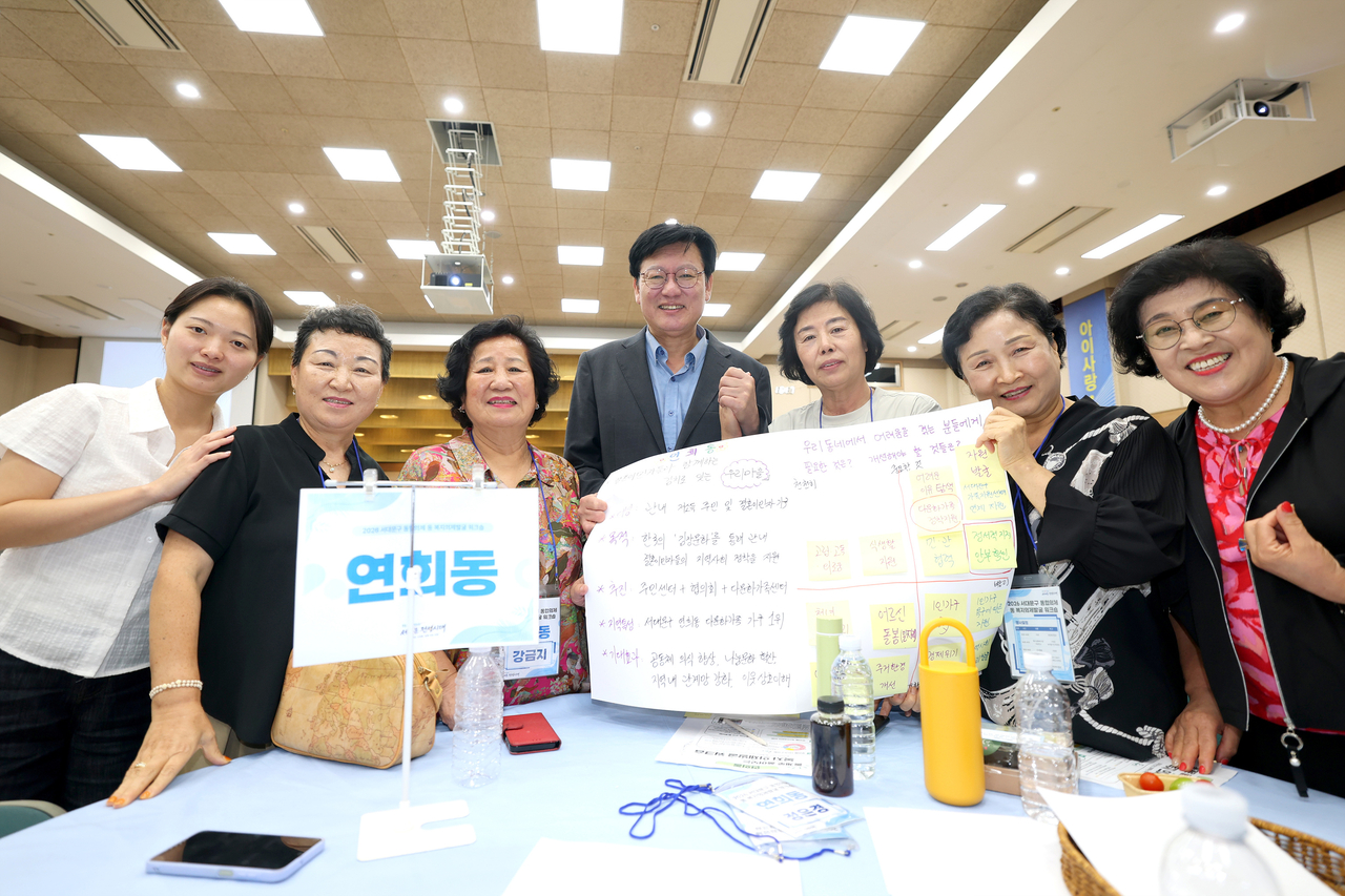 박운기(가운데) 서대문구청장과 연희동 주민들이 주민 총회를 열어 맞춤형 복지 사업을 결정한 뒤 기념활영을 하고 있다.  [서대문구 제공]