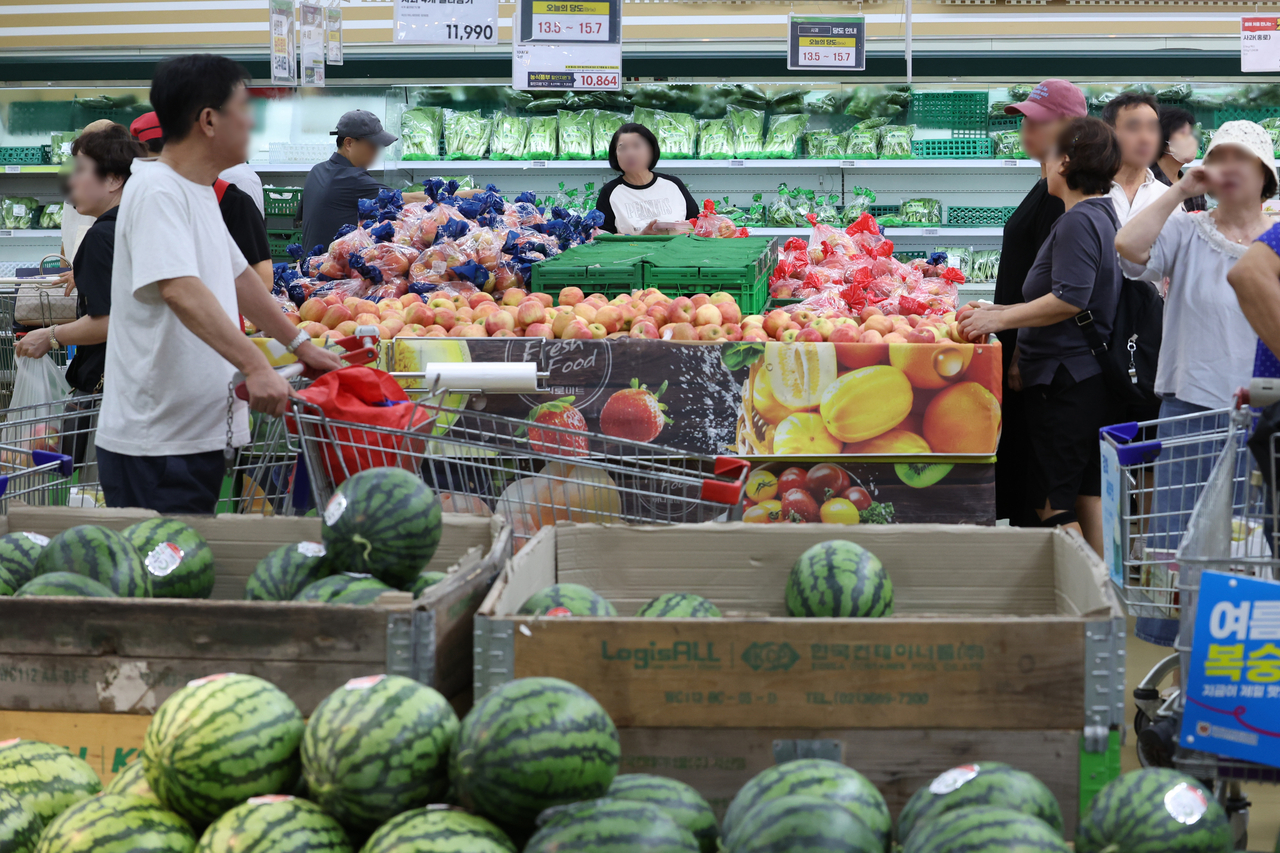 Shoppers purchase groceries at a supermarket in Seoul on Sunday. (Yonhap)