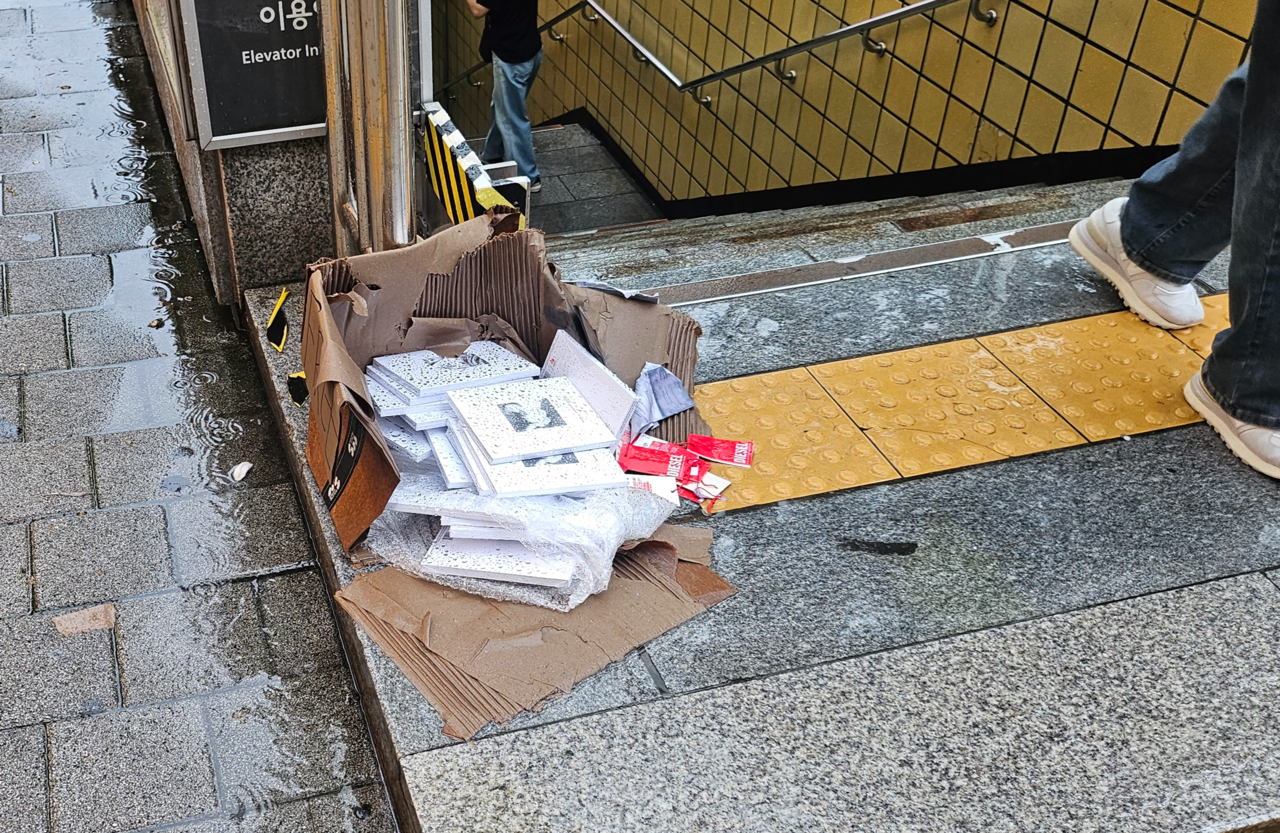 Boxes of K-pop albums left outside an exit of Ewha Womans University Station on Seoul Metro Line 2 on Monday. (Kim Gwang-woo)