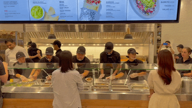 Staff at Chipotle's first Asian store in Seoul prepare food for media attendees. (No Kyung-min/The Korea Herald)