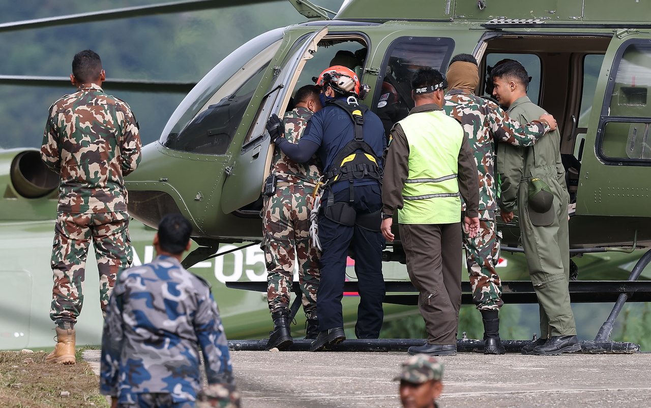 Members of South Korea's government rapid response team board a helicopter at a Nepali military base in Dhunche, Rasuwa district, Nepal, on Tuesday, as part of search efforts for nine South Koreans missing following massive floods. (Yonhap)