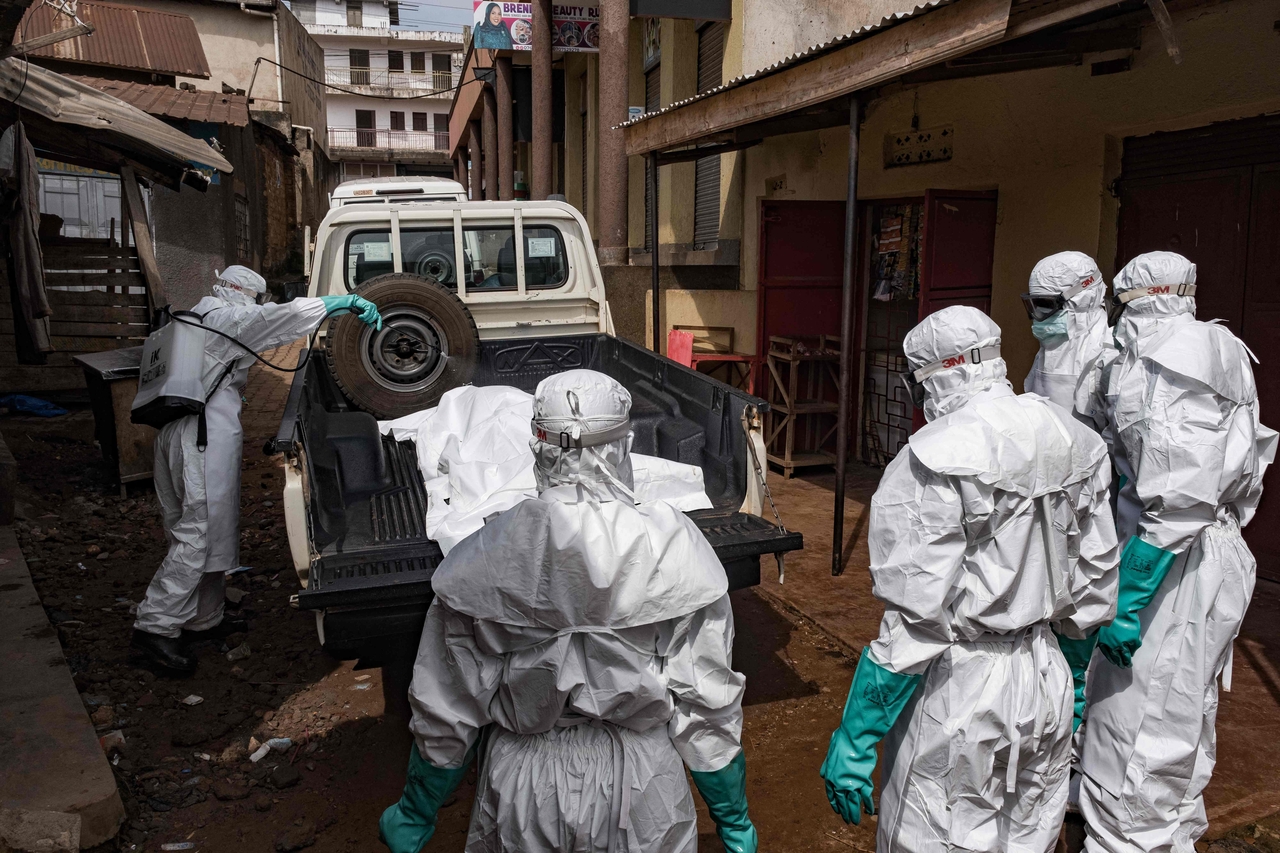 Workers from the Uganda Red Cross Society spray disinfectant during the evacuation of the body of a suspected Ebola victim in Kampala, Uganda, in May. (AFP-Yonhap)