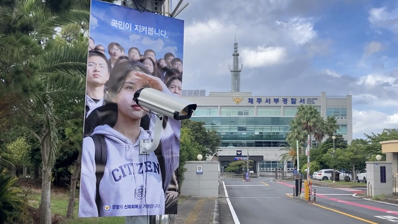 A guerrilla campaign poster satirizing the Jeju police force hangs in front of Jeju Seobu Police Station on Jeju Island on Sunday, following an investigation into an officer at the station over his alleged mishandling of missing person cases. (Jeski Social Campaign)