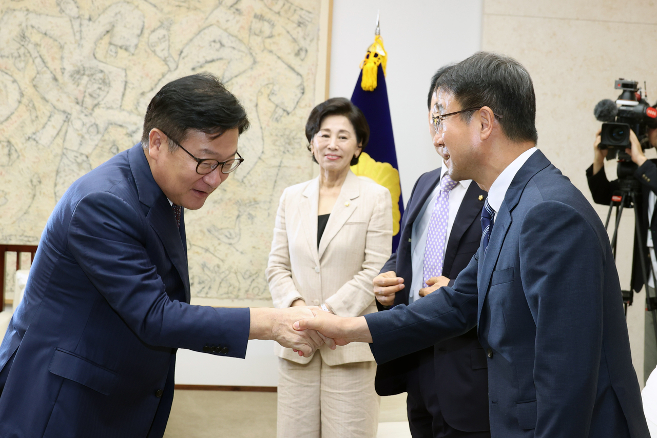 Floor leaders of the rival parties, Rep. Han Byung-do (right) of the Democratic Party and Rep. Jeong Jeom-sig of the People Power Party, shake hands before the opening ceremony of the regular session on Tuesday. (Pool photo via Yonhap)