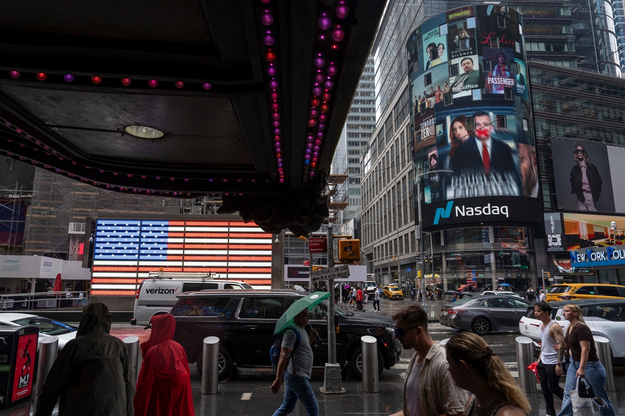 People walk past the Nasdaq MarketSite in New York, Aug. 6. (AP-Yonhap)