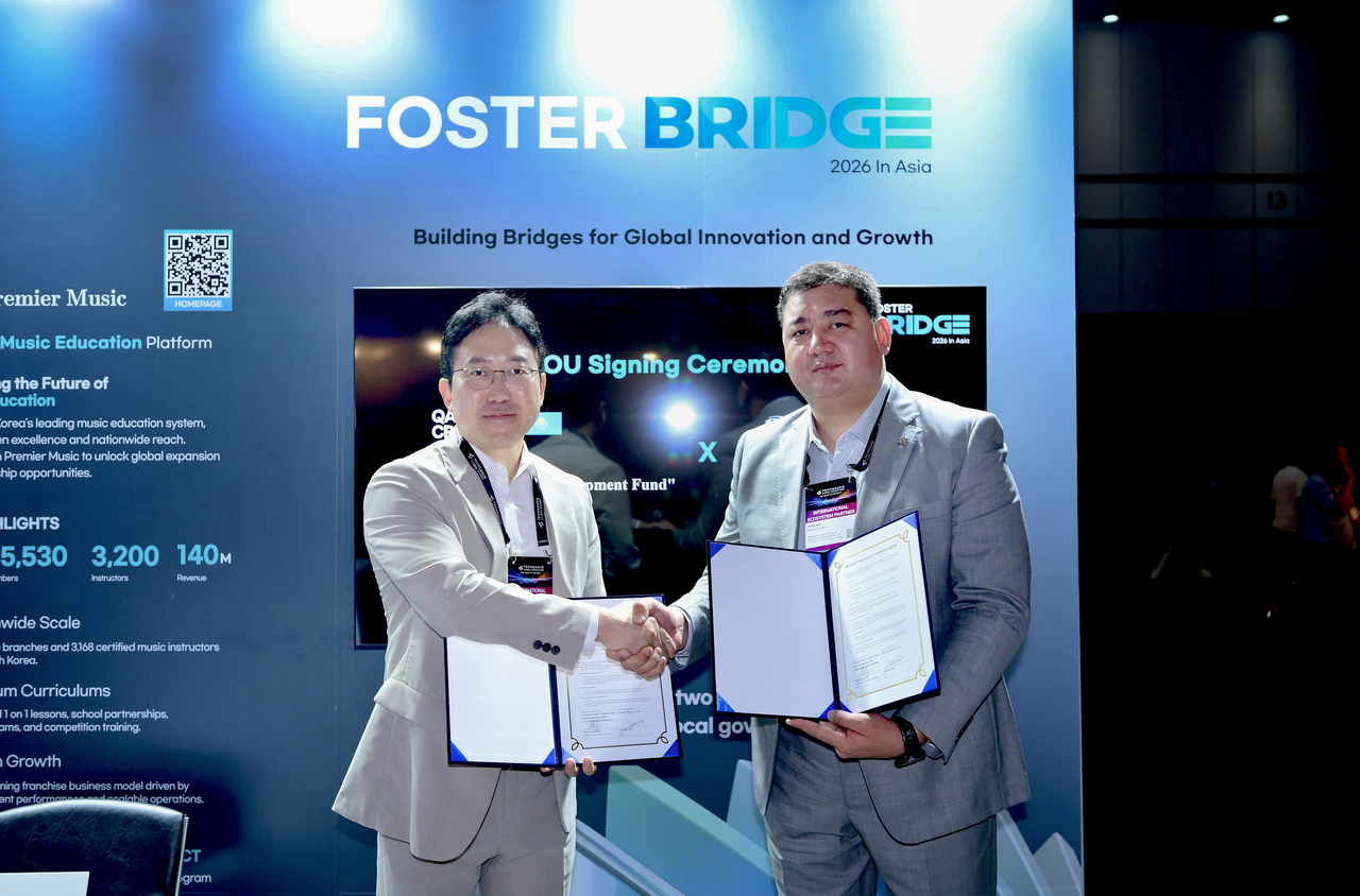 Park Jin-hyun (left), chairman of Fosterbridge, and Yerlan Kanalimov, chairman of the board of Kazakh Creative (Corporate Fund "Creative Industries Development Fund" of the Republic of Kazakhstan), pose for a photo after signing a memorandum of understanding at the Fosterbridge booth during the Techsauce Global Summit 2026 at the Queen Sirikit National Convention Center in Bangkok, Thailand, on Thursday (local time). [Fosterbridge]