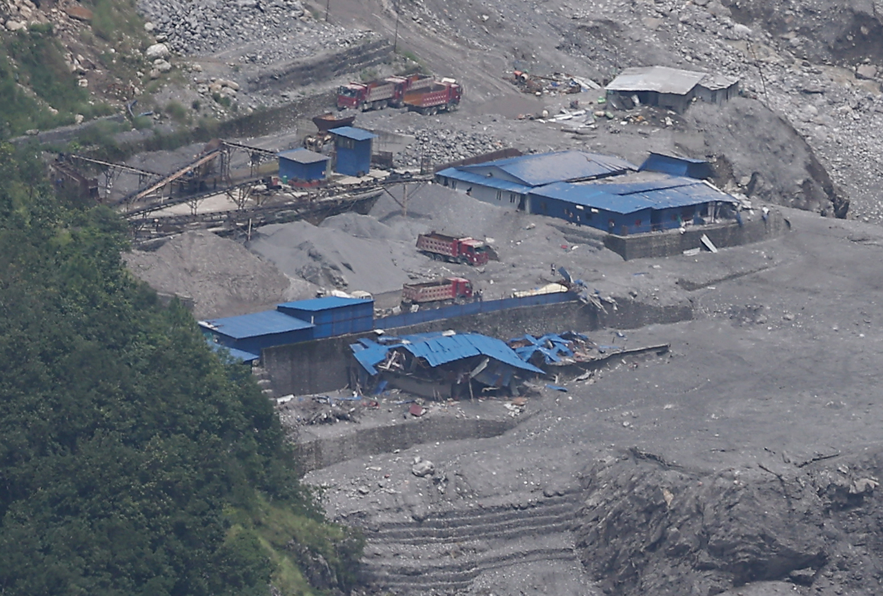 An office building near the weir dam in the Rasuwa district of Nepal lies buried under mud and debris on Tuesday (local time), as members of a South Korean government joint rapid-response team attempt to reach the site to search for nine missing South Korean nationals following massive flooding. [Yonhap]