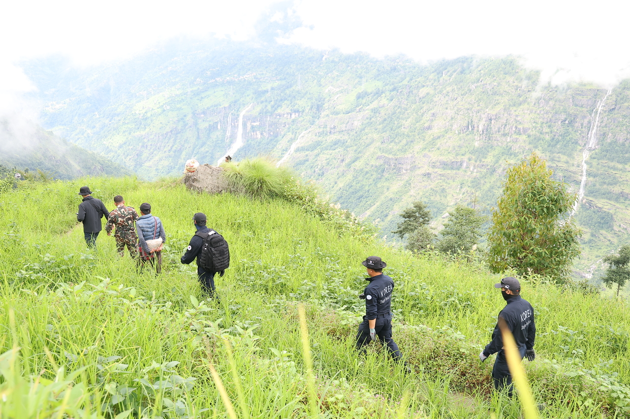 Members of a ground search team travel through Ramche, Rasuwa district, Nepal, on Wednesday, heading toward the flood-hit Upper Trishuli-1 (UT-1) hydropower plant construction site. (Yonhap)