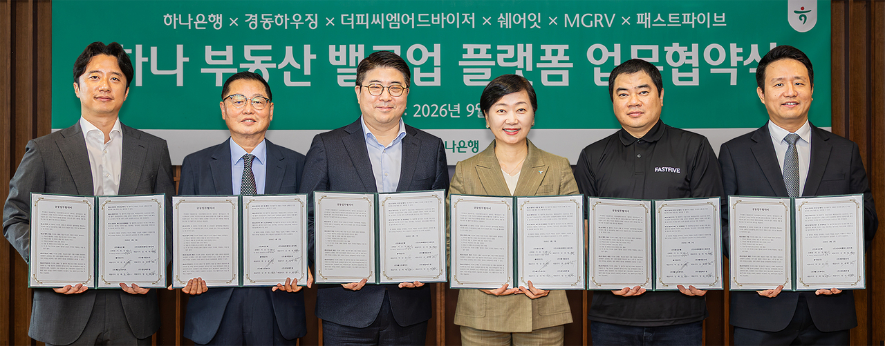 Lee Eun-jeong (fourth from left), head of Hana Bank's wealth management division, poses with senior representatives of partner companies after an MOU signing ceremony. [Hana Bank]