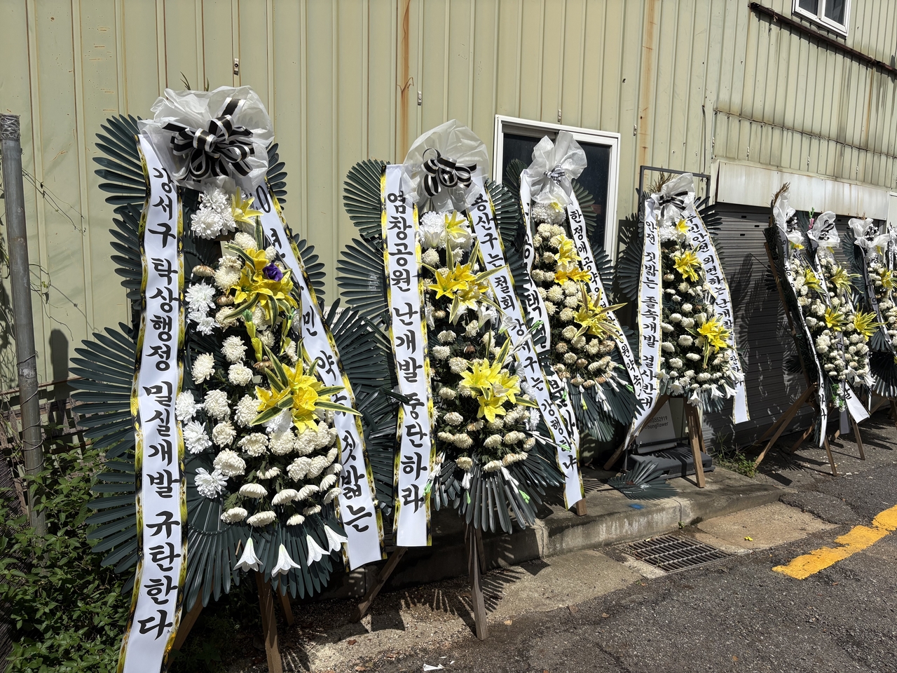 Funeral wreaths bearing messages opposing housing development stand in front of Yeomchang Neighborhood Park in Yeomchang-dong, Gangseo-gu, Seoul, on Wednesday. (Yoon Seung-hyun)