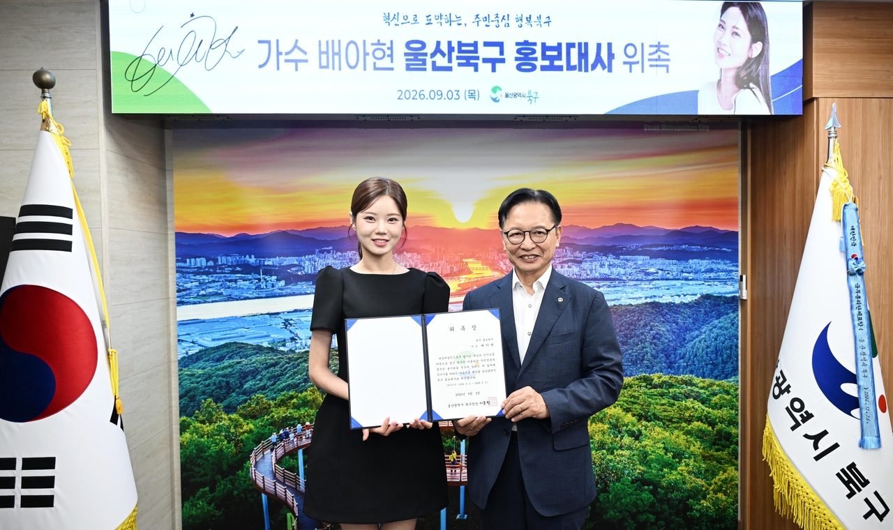 Ulsan Buk-gu District Mayor Lee Dong-kwon (right) presents singer Bae A-hyeon with her honorary ambassador appointment certificate at his office Thursday. [Ulsan Buk-gu District Office]