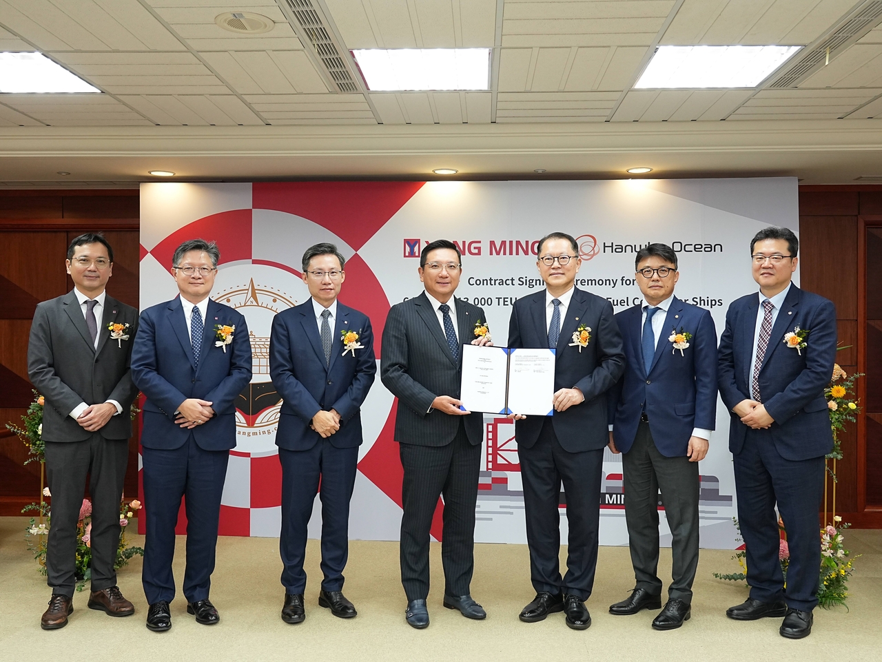 Hanwha Ocean CEO Kim Hee-chul (third from right) and Yang Ming Marine Chairman Tsai Feng-ming (fourth from right) pose with officials from both companies after a contract signing ceremony held recently in Taiwan. [Hanwha Ocean]