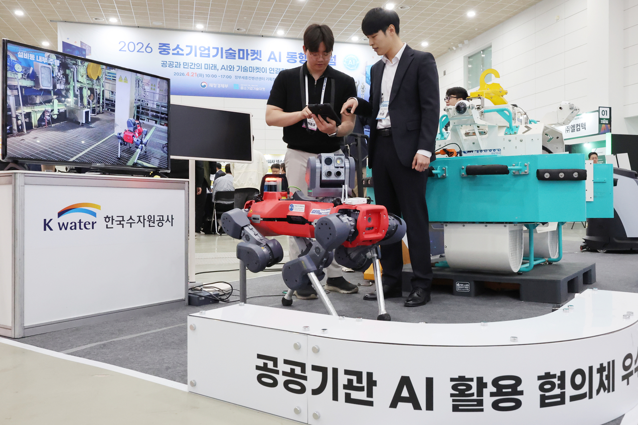 Officials from Korea Water Resources Corporation and an AI robot developer demonstrate a robot designed for water treatment plant inspections at the 2026 SME Technology Market AI Forum, held Tuesday at the Government Sejong Convention Center in Sejong. [Yonhap]