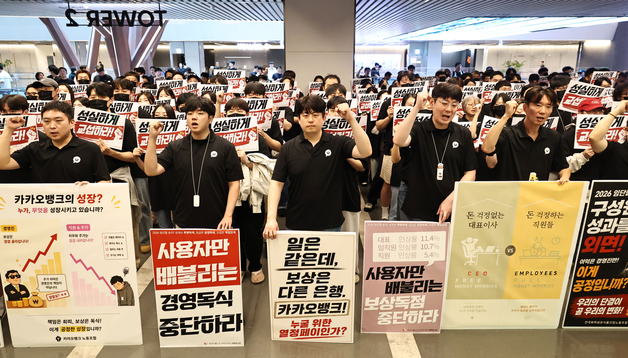 21일 경기도 성남 판교 카카오뱅크 본사 앞에서 카카오 노조원들이 피켓을 들고 구호를 외치고 있다.  이날 카카오뱅크 노조는 오는 31일 전일 파업을 진행한다고 밝혔다. [연합]