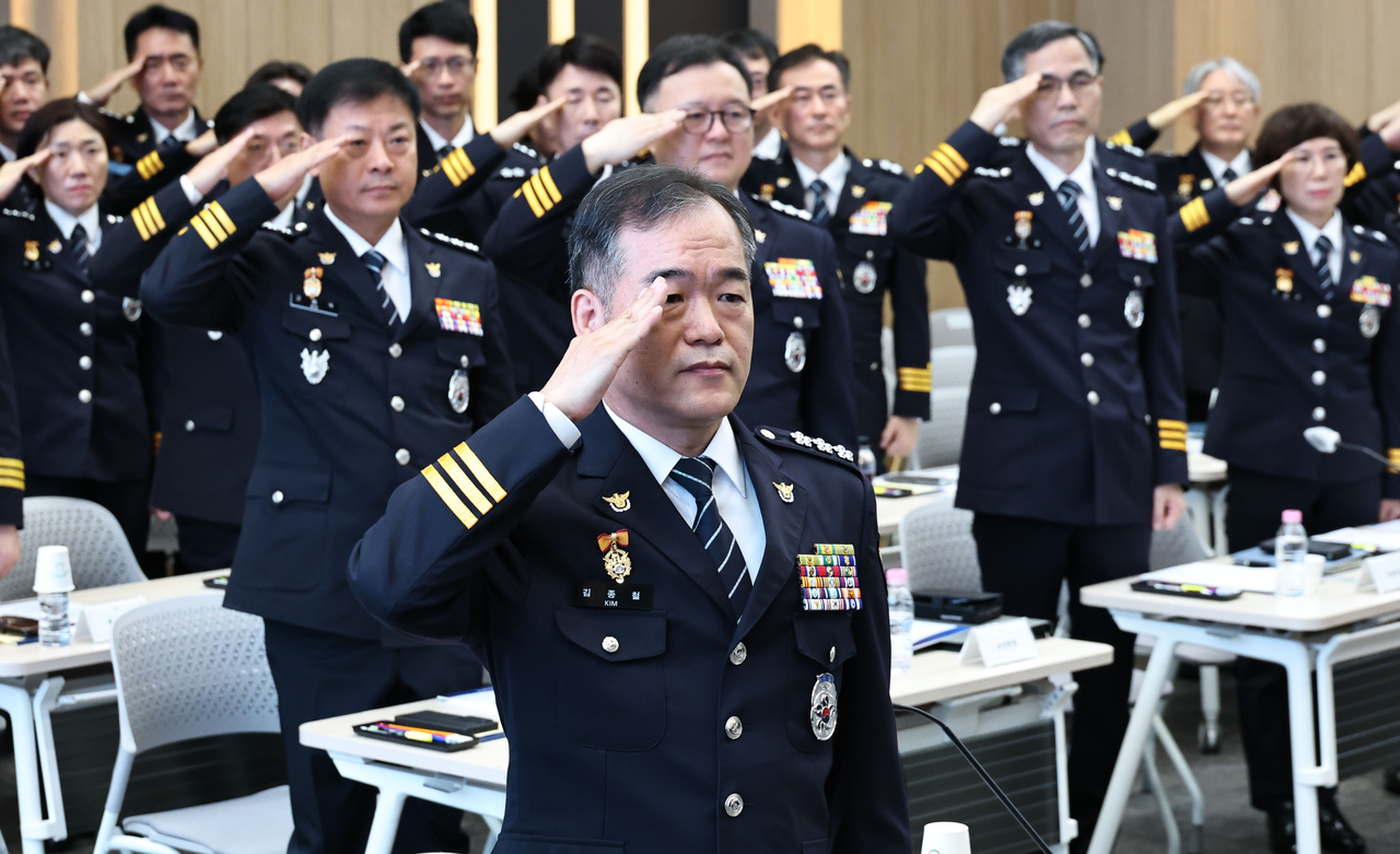Acting Commissioner General of the Korean National Police Agency Kim Jong-chul (center) salutes the Korean flag during a meeting of 18 regional police chiefs at the KNPA's headquarters in Seodaemun-gu, Seoul. (Yonhap)
