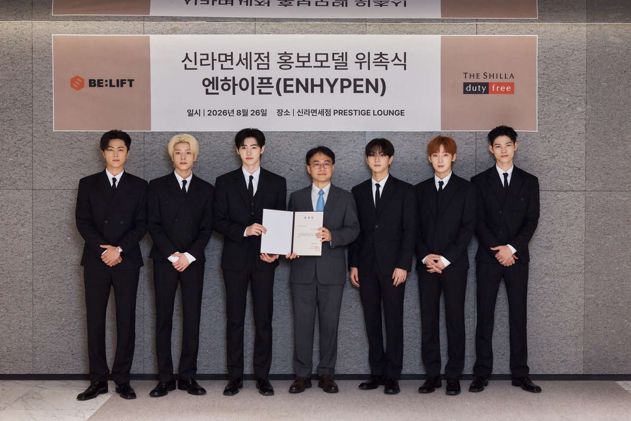 Ahn Jae-ho (center), senior managing director of the sales support team at Shilla Duty Free, poses with Enhypen at an ambassador appointment ceremony held at the Shilla Duty Free Seoul store on Aug. 26. [Shilla Duty Free]