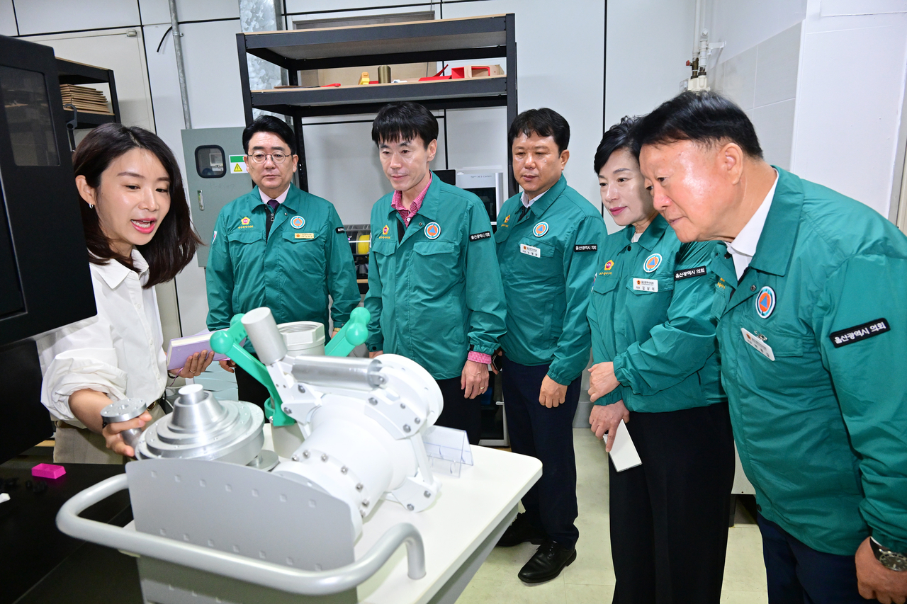 Members of the Ulsan City Council's Industry and Construction Committee listen to an explanation of prototype manufacturing equipment during a visit to Ulsan Technopark on Friday. [Ulsan City Council]