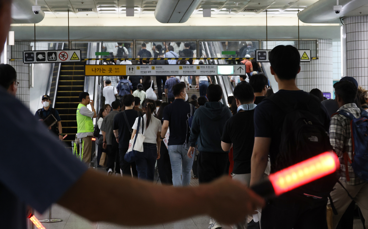 Staff members manage crowds at Yeouinaru Station near the venue of the Seoul International Fireworks Festival 2026 in Seoul on Saturday. (Yonhap)