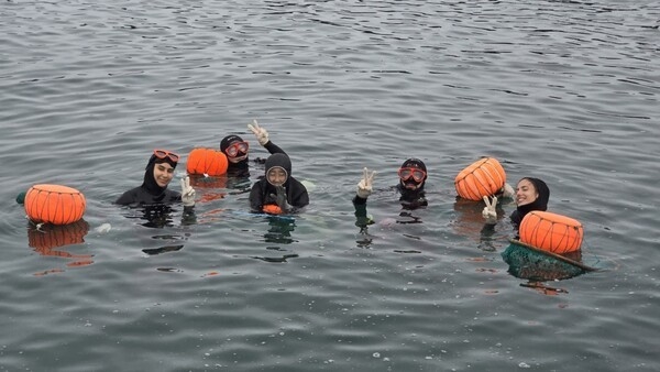 French participants take part in a traditional haenyeo diving experience with local haenyeo in Seogwipo, Jeju Island, July 16. (Jeju Tourism Organization)