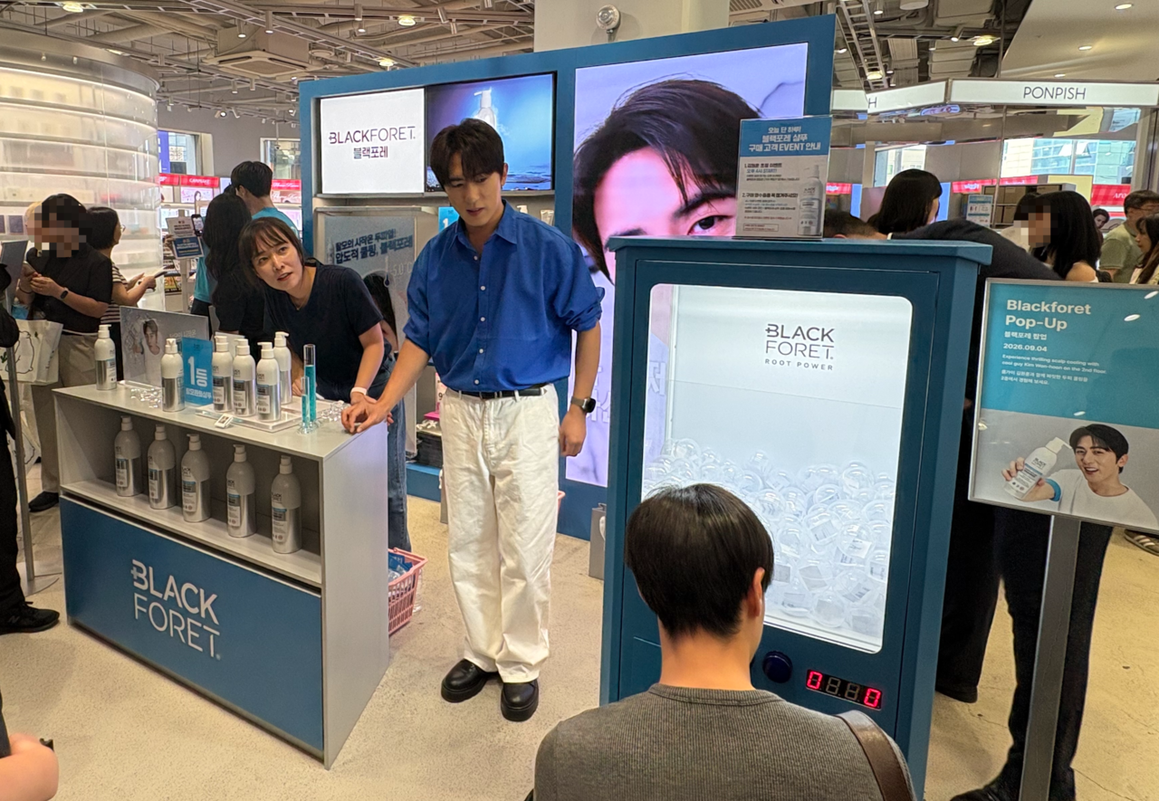 Comedian Kim Won-hun, brand model for Blackfore, helps visitors participate in a capsule-toy prize draw at the Blackfore pop-up store held Friday afternoon at the Musinsa Megastore in Seongsu-dong, Seongdong-gu, Seoul. By Kang Seung-yeon