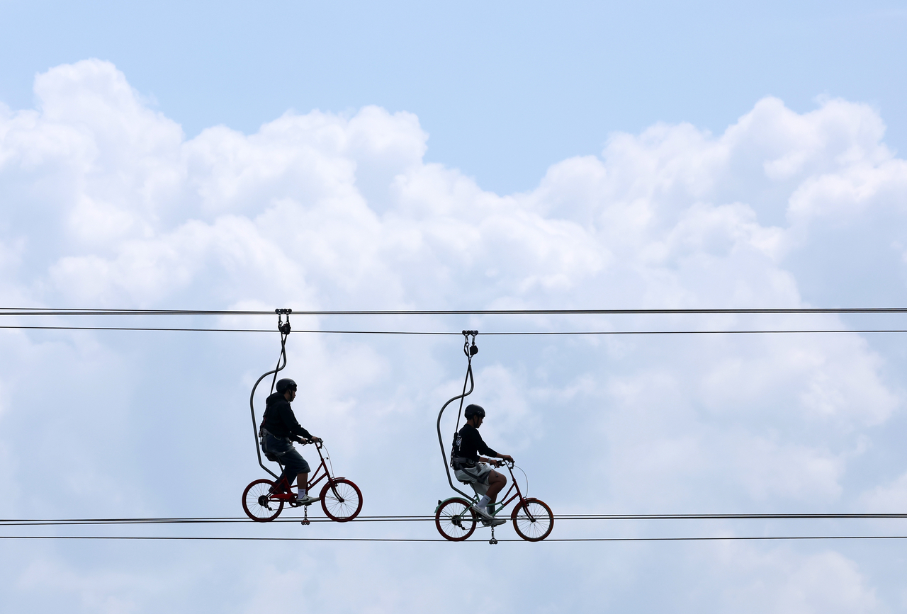 Two visitors ride overwater bikes near Anmok Beach in Gangneung, Gangwon Province, Sunday. (Yonhap)