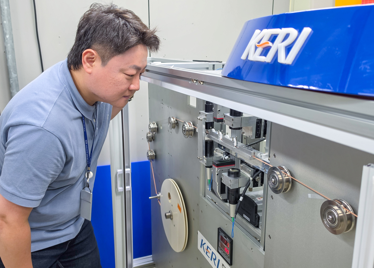 Researcher Park In-sung checks the thickness and width of high-temperature superconducting wire using the 3D non-contact ultra-precision inspection system. [Korea Electrotechnology Research Institute]