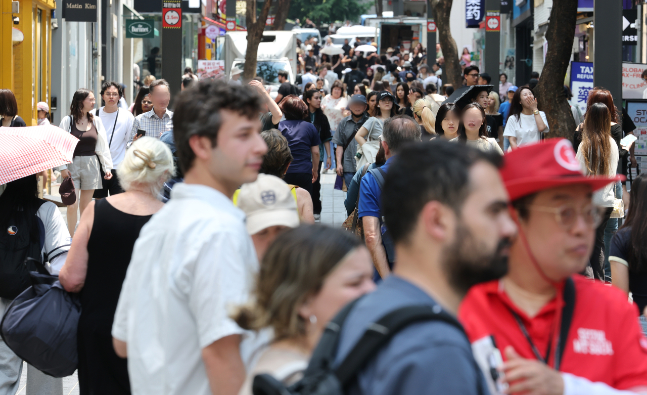 The Myeongdong shopping district in central Seoul is crowded with foreign tourists and Seoul citizens on June 9. (Yonhap)
