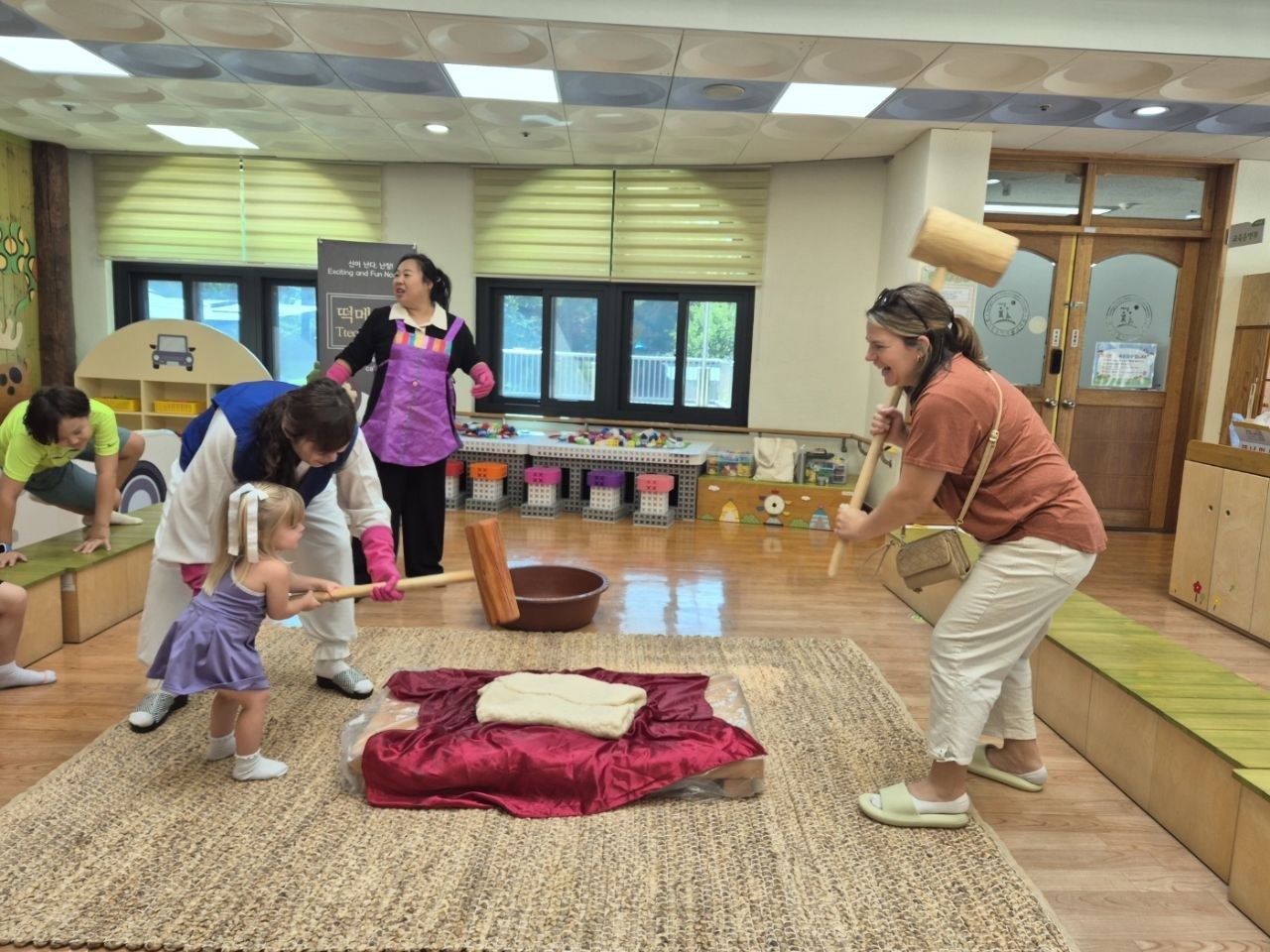 Participants at a cultural exchange event held by the Gyeonggi Provincial Office of Education for young children from Korean and American families affiliated with Camp Humphreys pound rice cakes on Saturday in Pyeongtaek, Gyeonggi Province. (The Gyeonggi Provincial Office of Education)